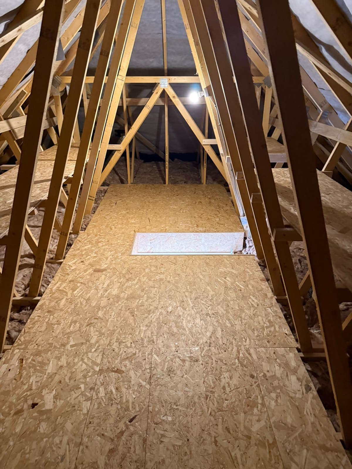 Finished loft boarding and hatch in a Canterbury loft, lit from the gable end