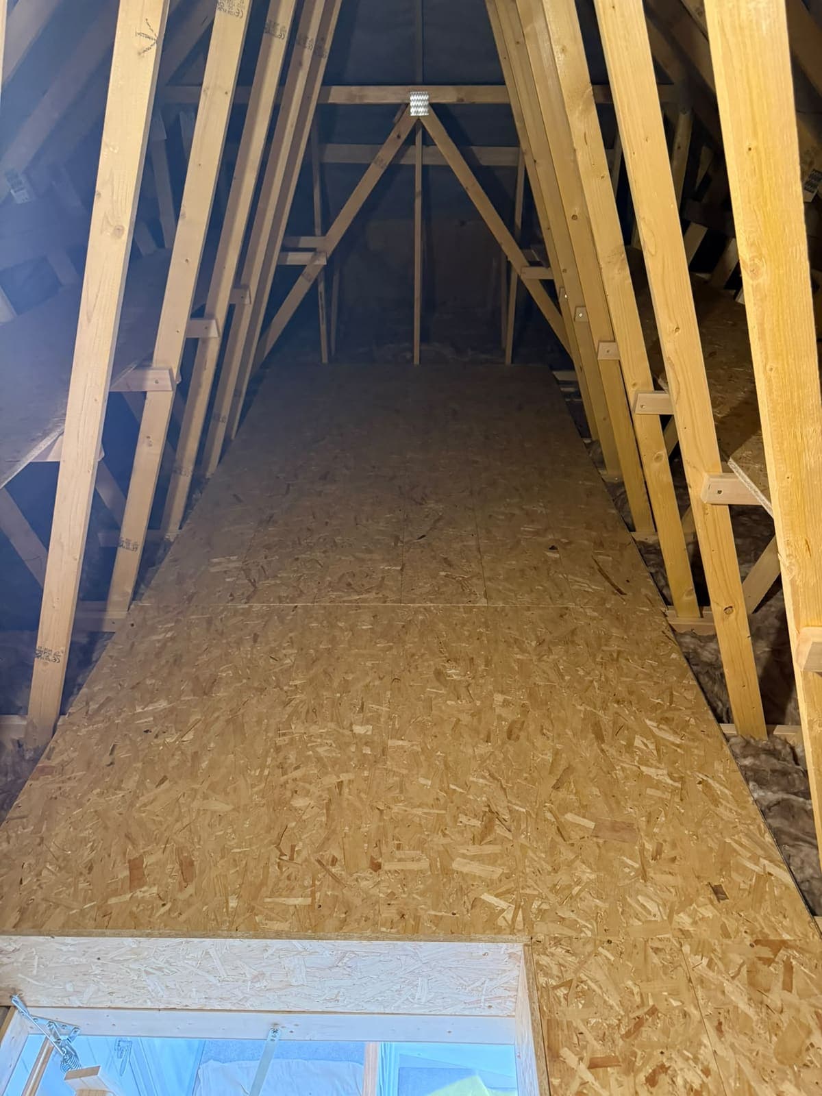 Loft boarding seen from the hatch, running between the roof trusses