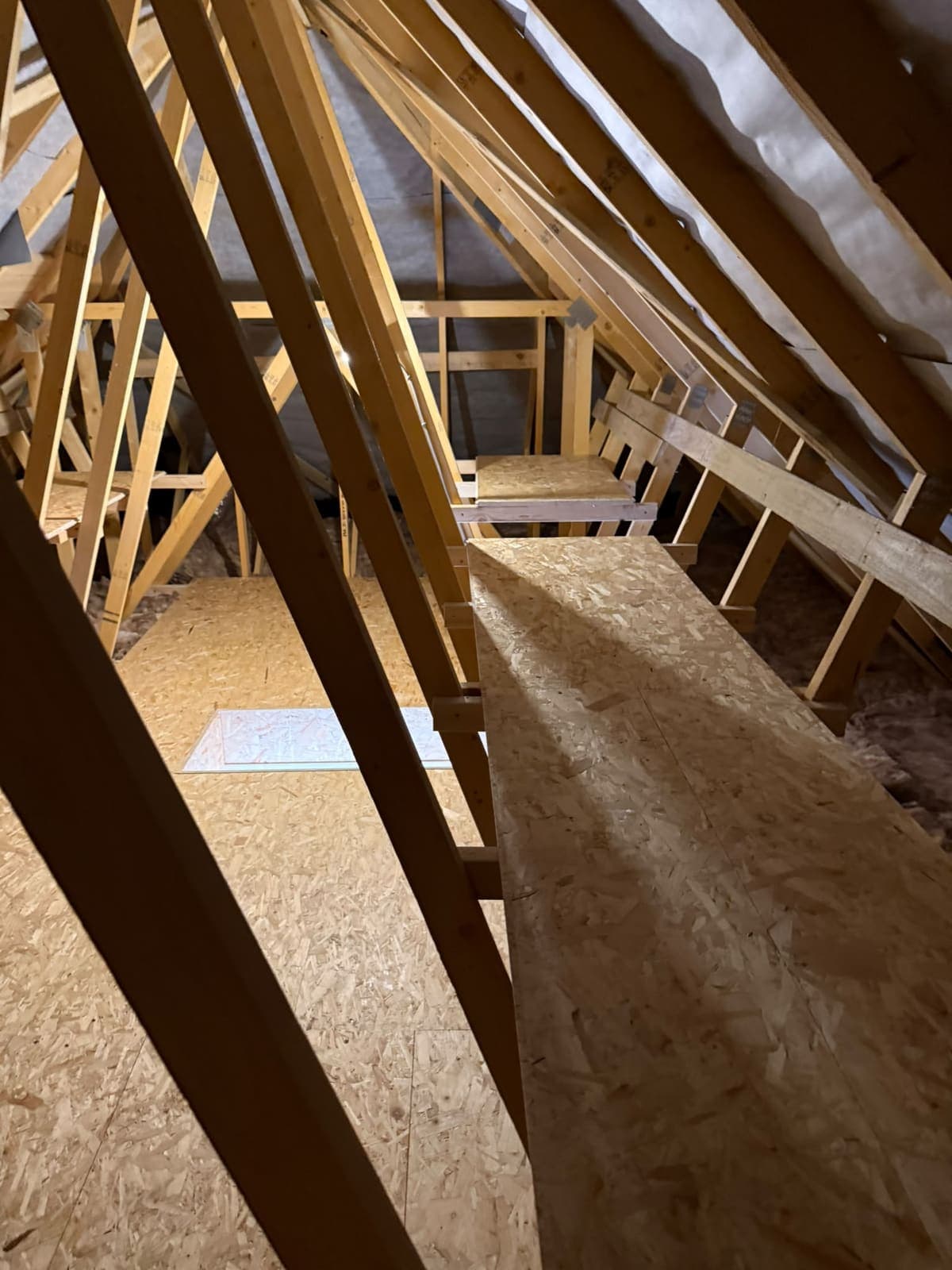 Boarded loft floor with a raised side section between the trusses