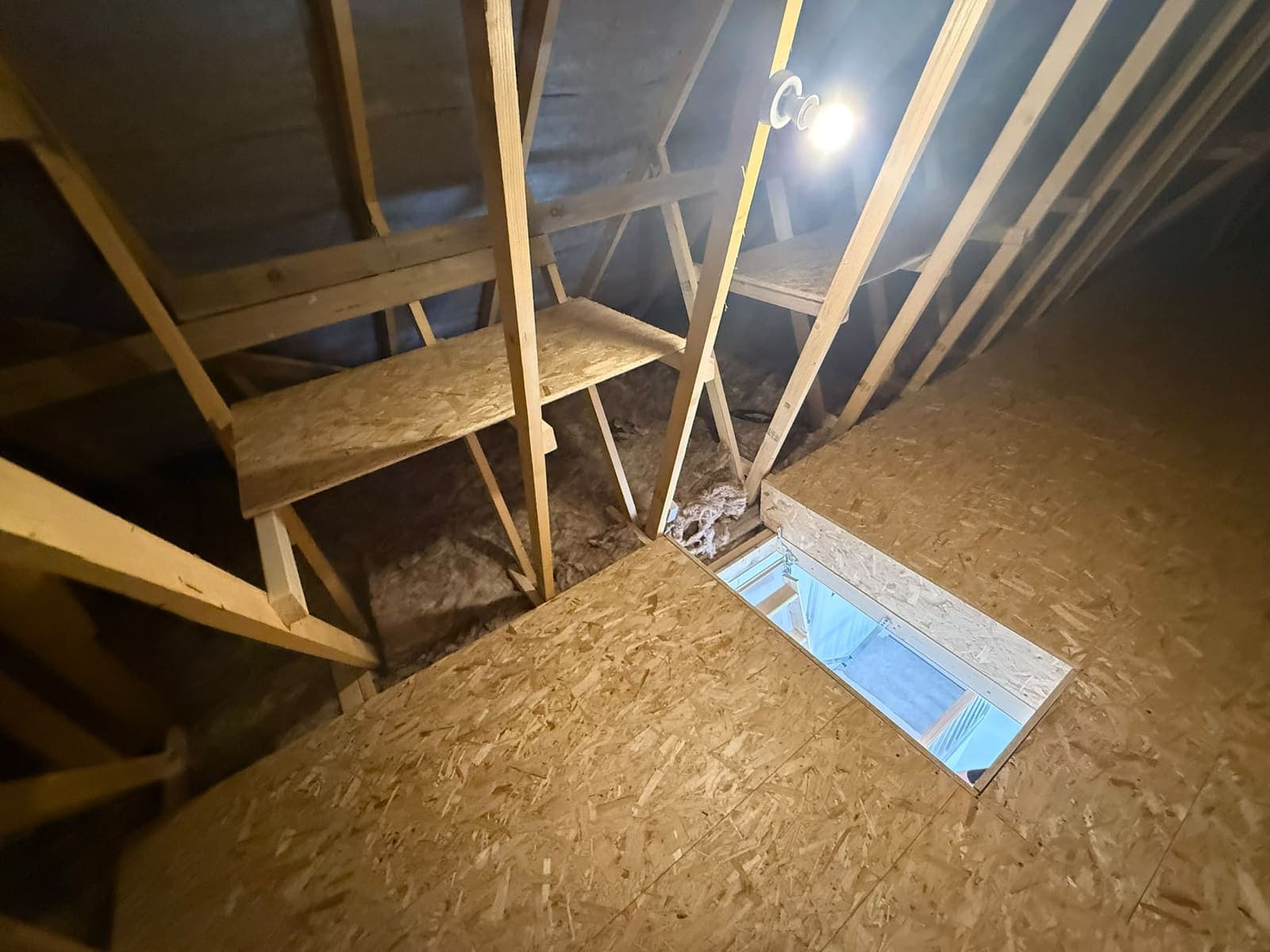 Loft hatch opening and corner shelf with the loft light on