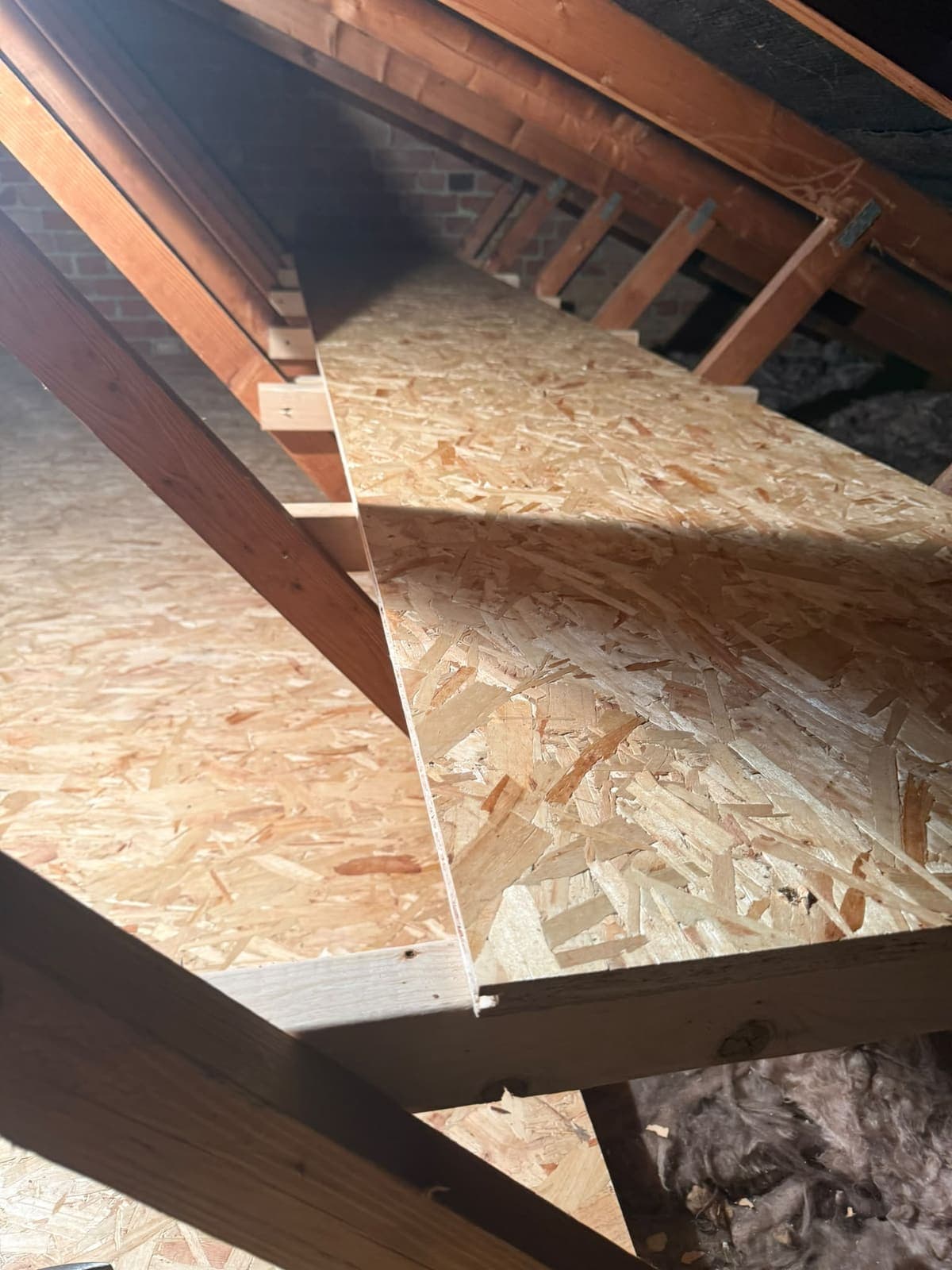 Loft shelving built between the trusses beside the boarded floor