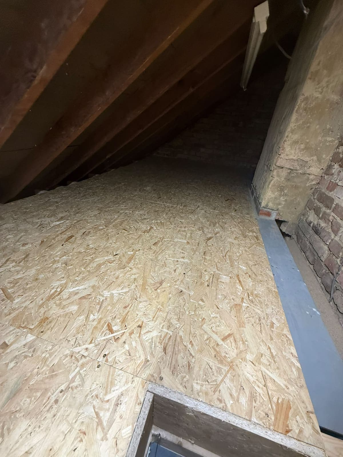Boarded loft floor under the eaves after the insulation was laid
