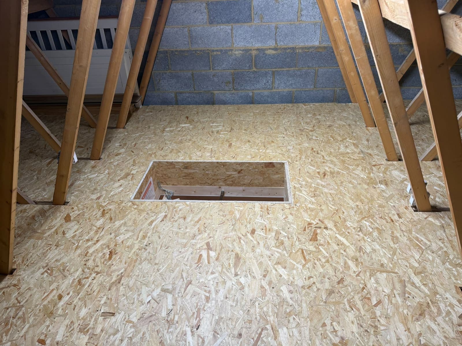 Wide view of the finished loft boarding under a trussed roof in Chattenden