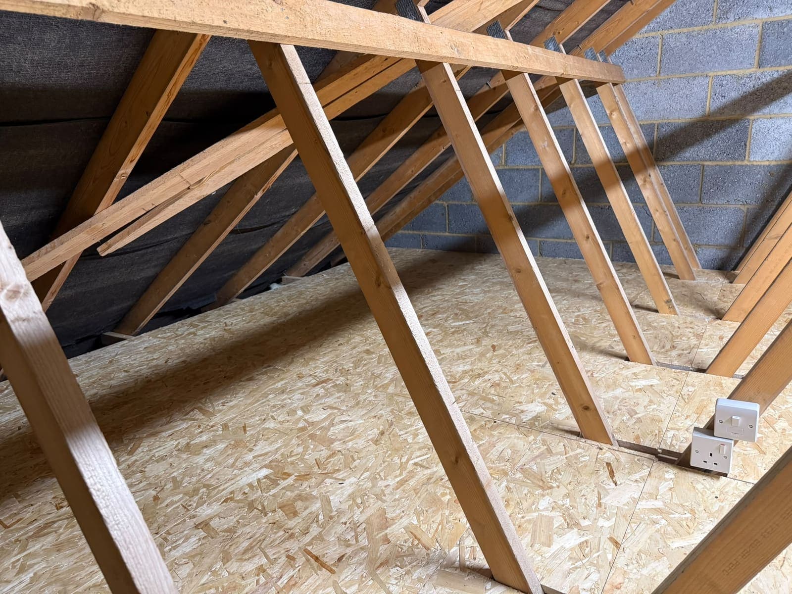 Loft boarding cut neatly around the roof truss webs