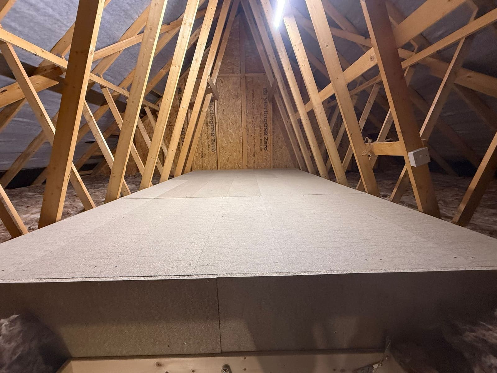 Raised loft floor sitting above the insulation between the trusses