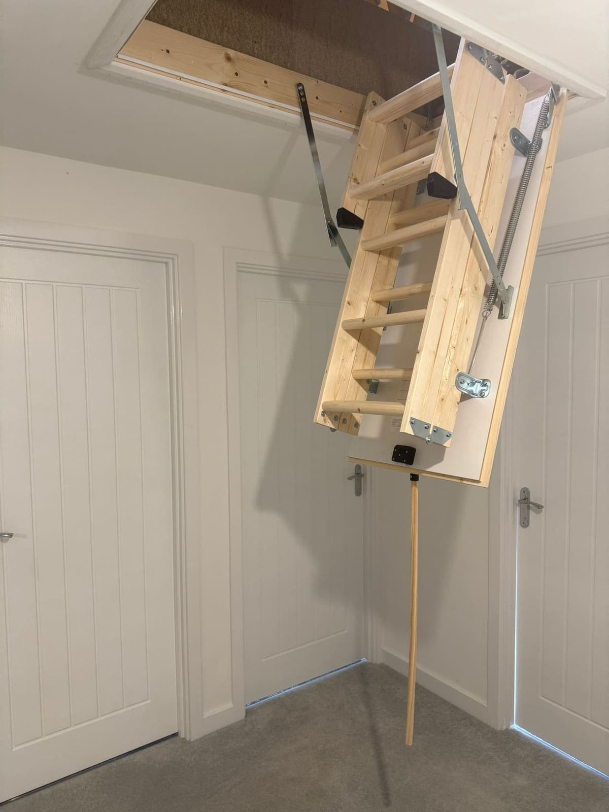 Wooden loft ladder unfolding from the hatch