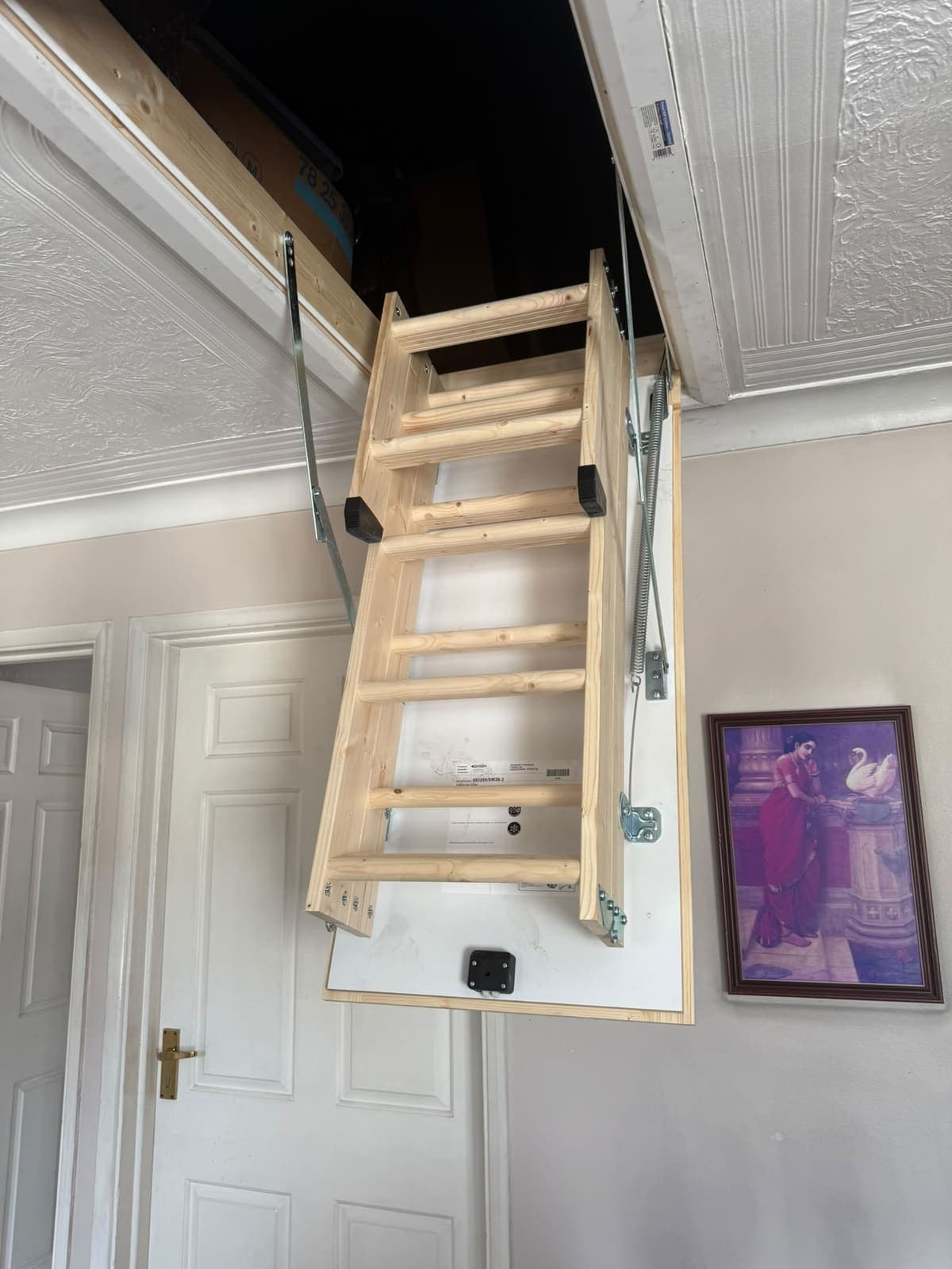 Wooden loft ladder folding down from the hatch