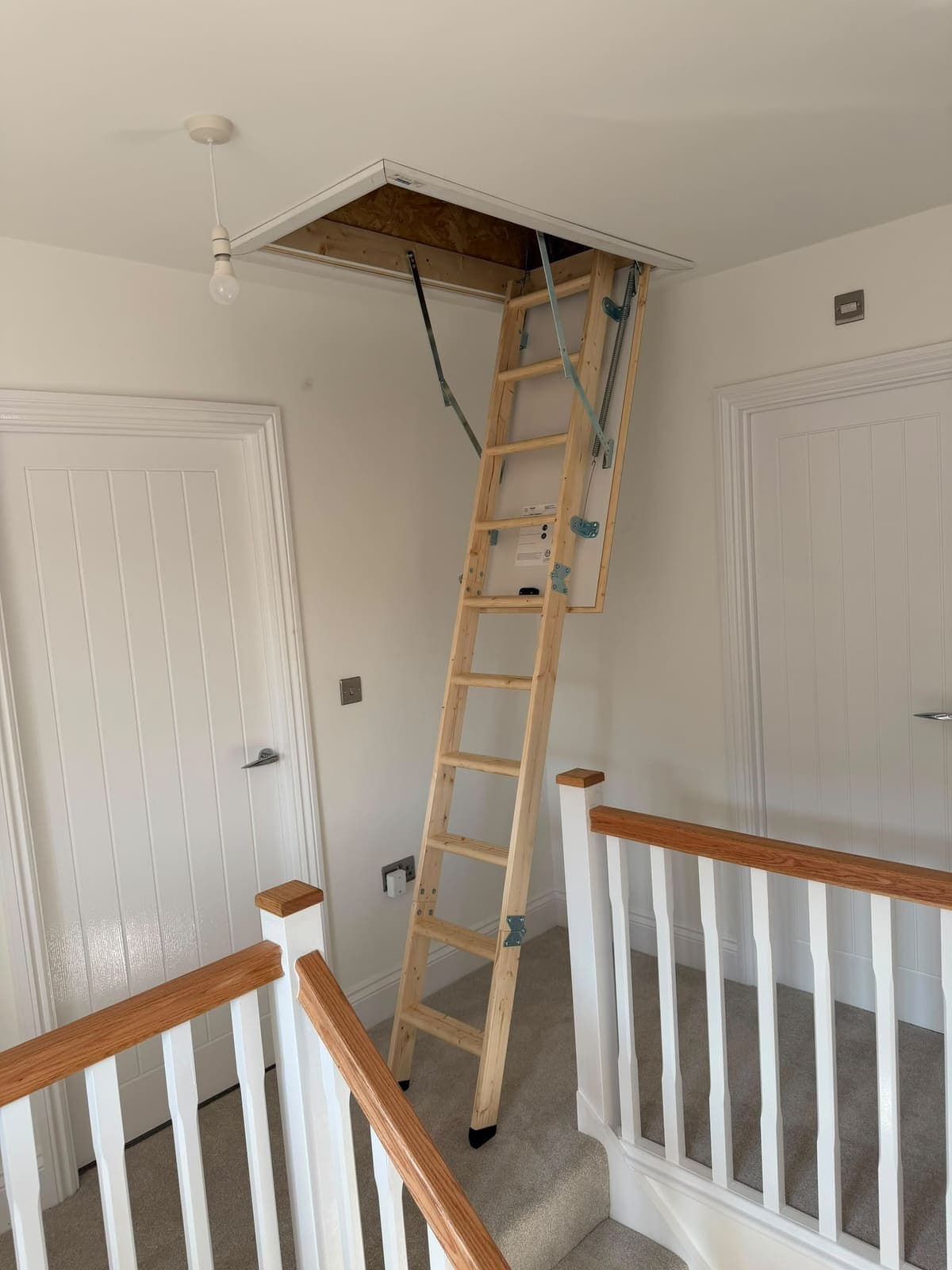 Wooden loft ladder fitted beside the stair balustrade