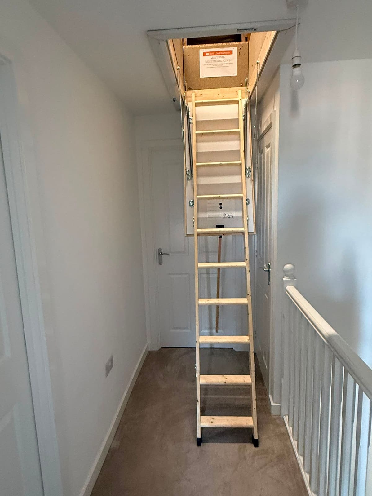 Wooden loft ladder down on a new build landing in Kent